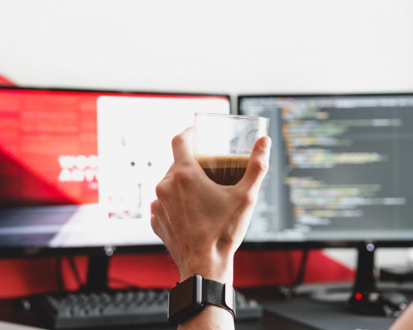 a glass of coffee in front of a computer screen