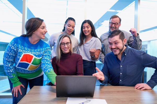 a group of happy people with a computer