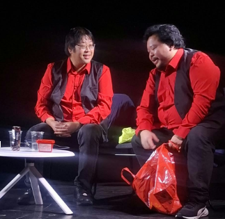 Jon Oslo 4 Two performers in matching red shirts and black waistcoats sitting on stage during an improvised comedy show